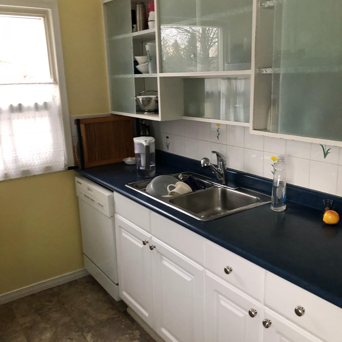 Kitchen before renovation — dated cabinets and worn counters