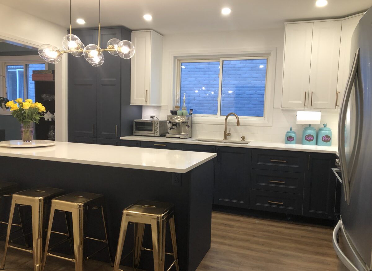 Two-tone navy and white kitchen with quartz waterfall island and brass fixtures — Reno-eX renovation