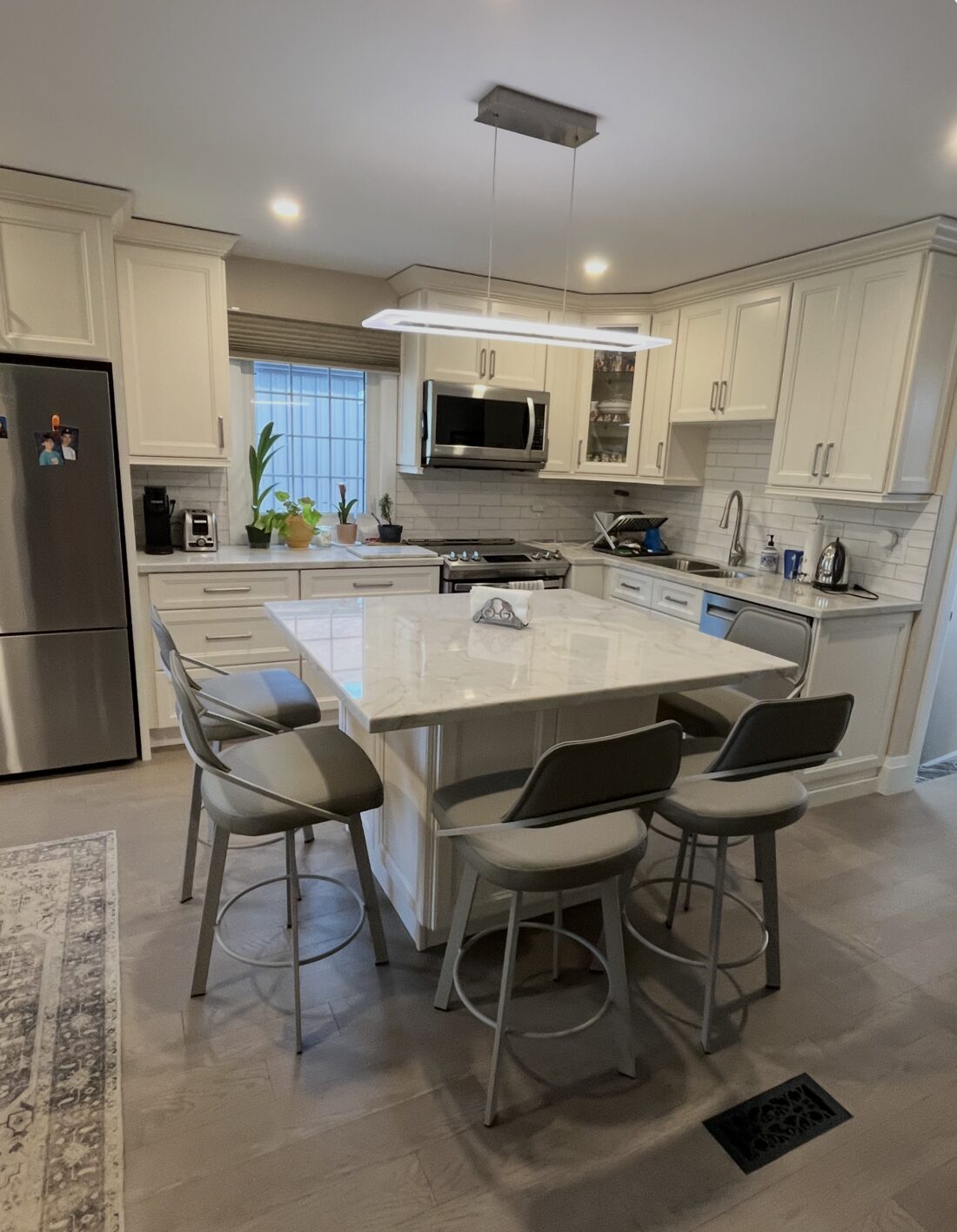 Open-concept kitchen with marble island, white cabinets and subway-tile backsplash — Reno-eX, Humberlea Park, Toronto 2025