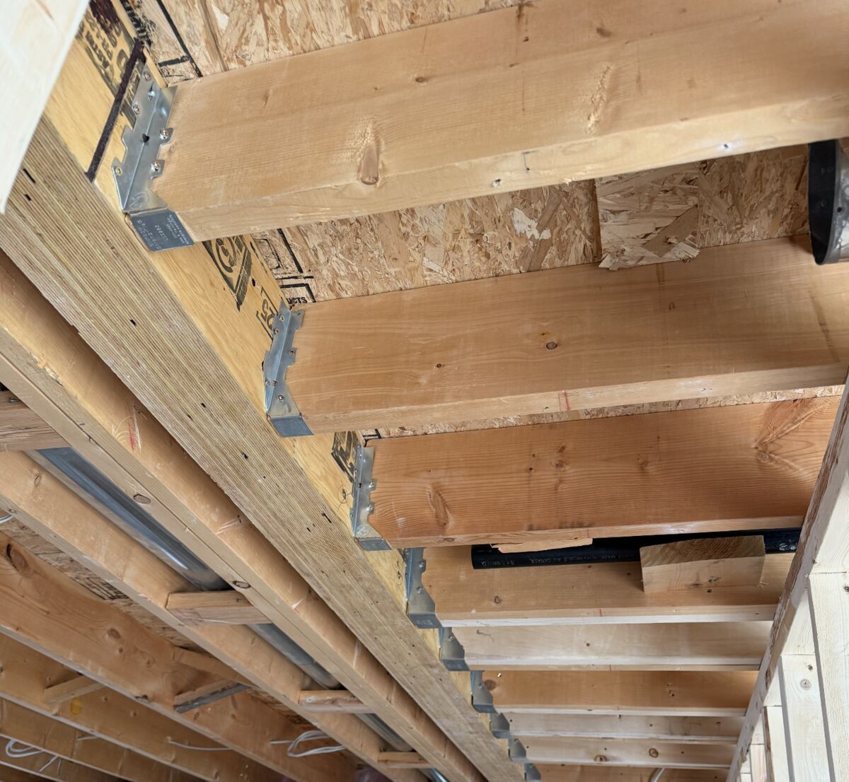 Engineered beams, joist hangers and a steel support beam — Reno-eX structural framing work